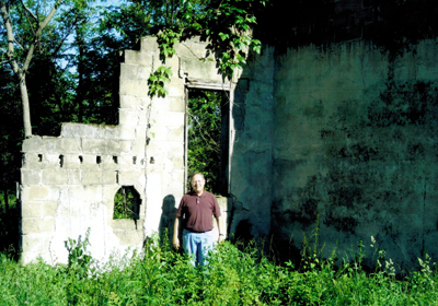 Gary Johnson inside the ruins of his grandfather Ed Sampson's movie house, Consol, IA 2011. Pay window is to Gary's right.